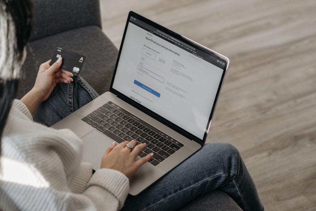 A Person Using Her Laptop while Holding a Credit Card